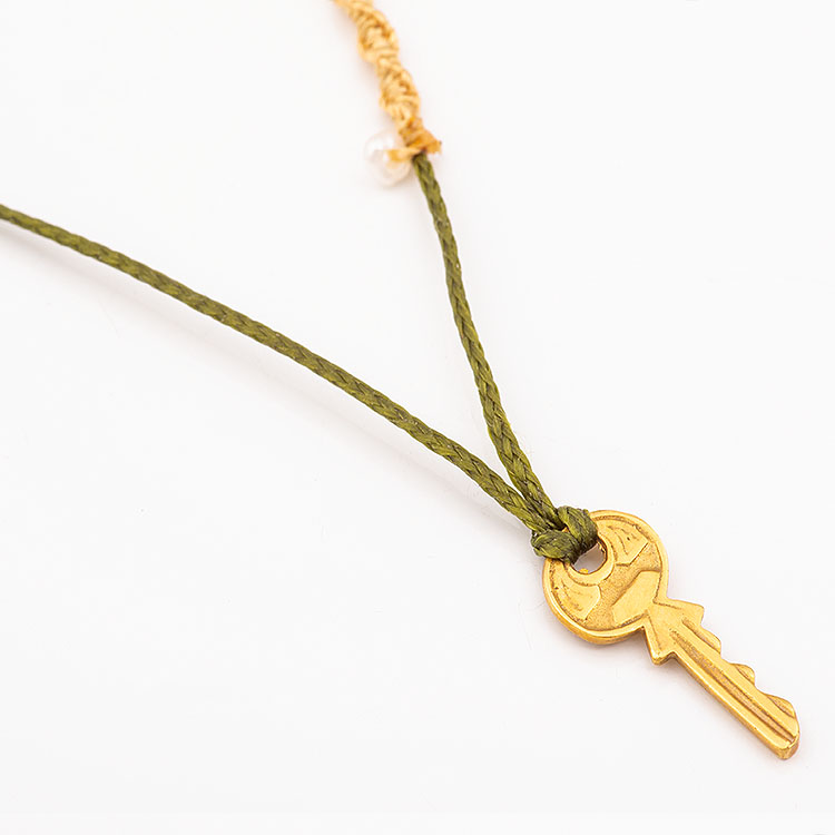 Necklace with an olive green cord and a K14 gold key motif.