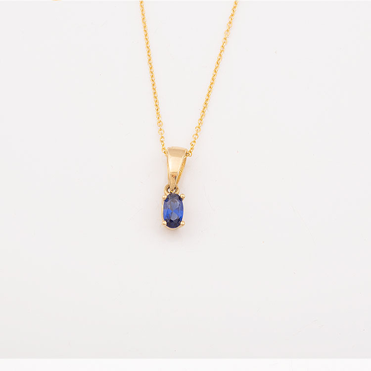 K14 gold necklace with an oval blue stone.
