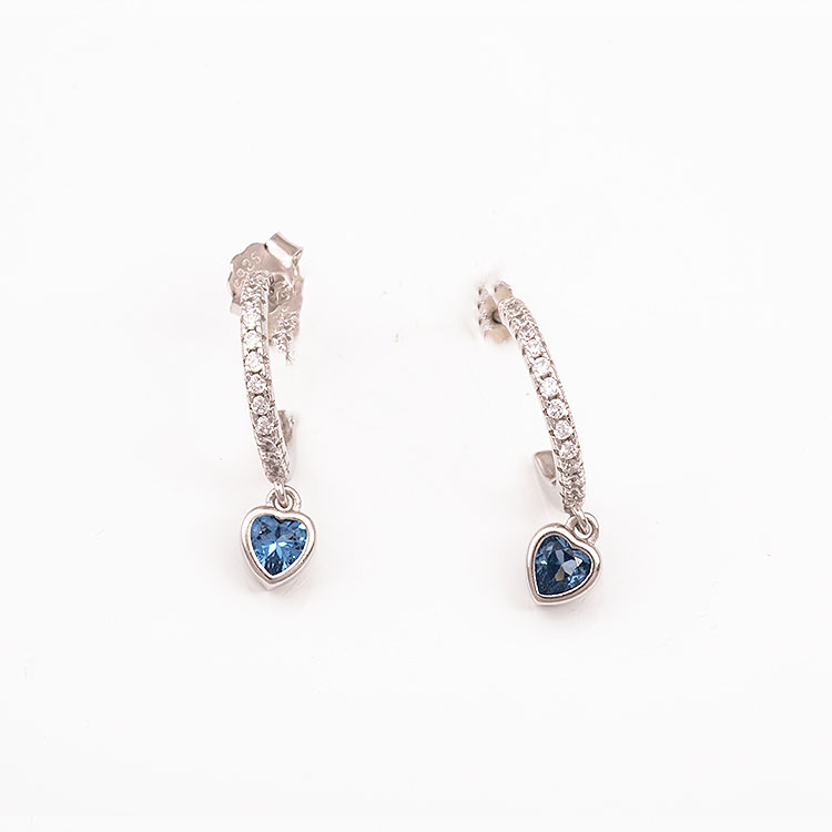 Ασημένια σκουλαρίκια, μικρά κρικάκια, με καρδούλα με γαλάζια πέτρα.
