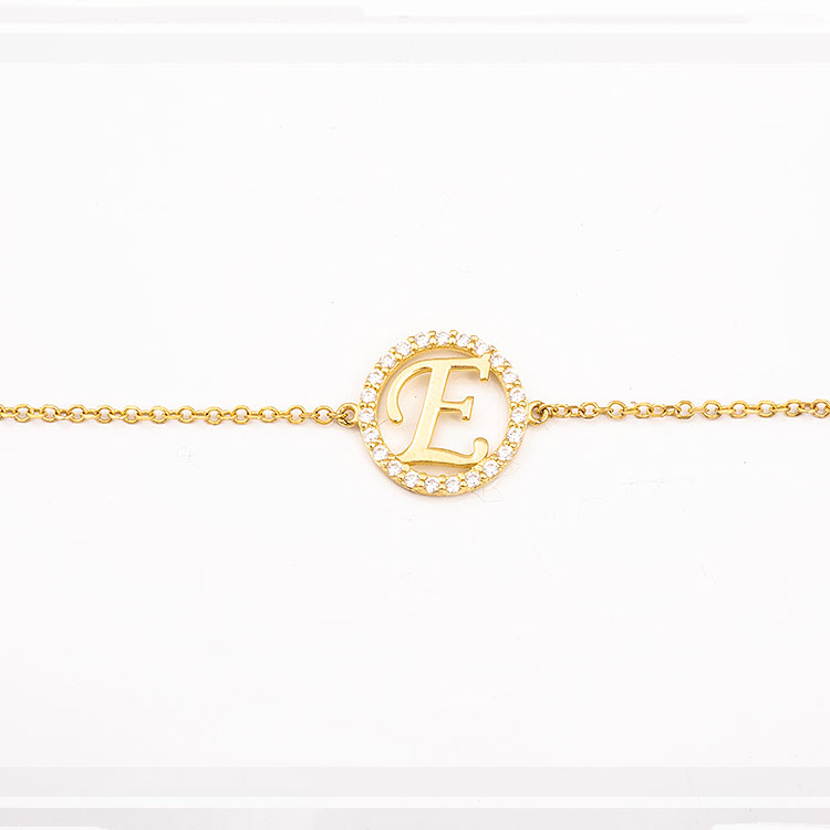K9 gold Initial E bracelet adorned with stones.