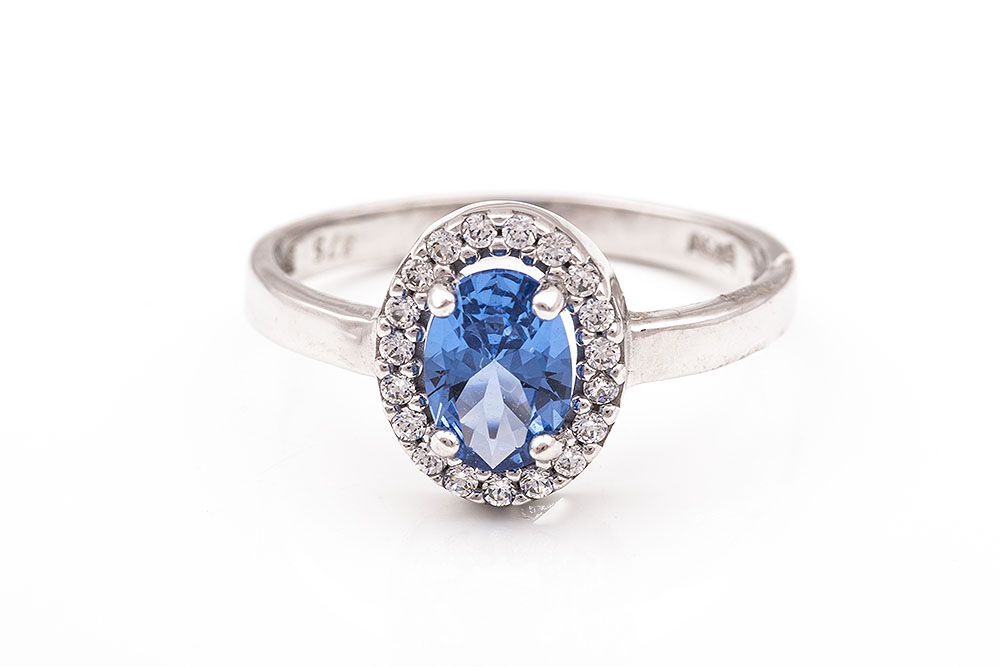 Λευκόχρυσο δαχτυλίδι Κ9 ροζέτα με οβάλ γαλάζια πέτρα.