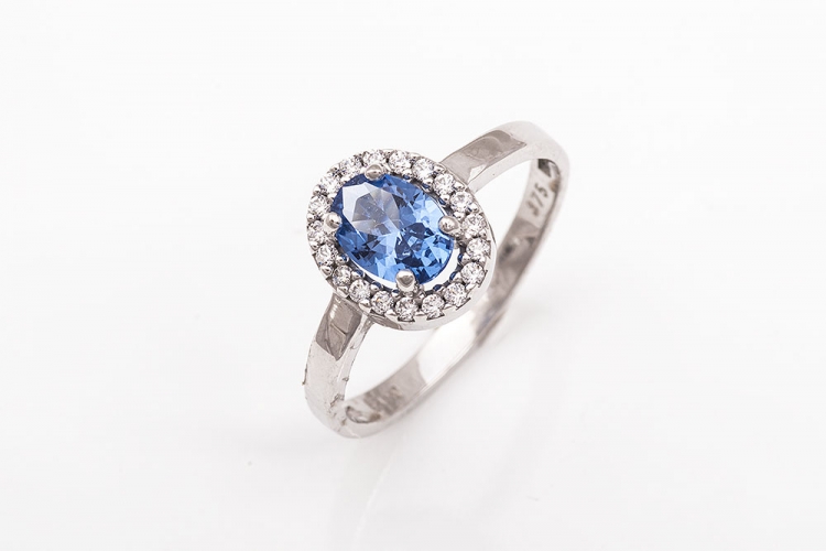 Λευκόχρυσο δαχτυλίδι Κ9 ροζέτα με οβάλ γαλάζια πέτρα.
